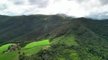 Nefes kesen görkemli bir hava manzarası canlı yeşil tarlalar ve bulutlu bir gökyüzünün altında yuvarlanan tepeler.