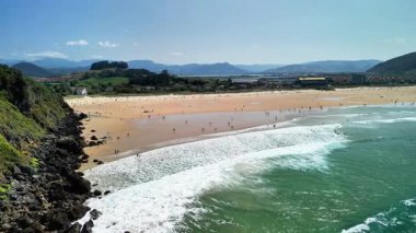 Sersemletici hava manzarası sakin bir plajı, sakin dalgaları, güneşlenenleri ve bereketli manzarayı gözler önüne seriyor.