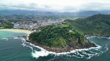 Bu hava manzarası, kıyı şeridi boyunca uzanan yeşil tepelerin canlı gök mavisi okyanus sularıyla tamamlandığını gösteriyor.