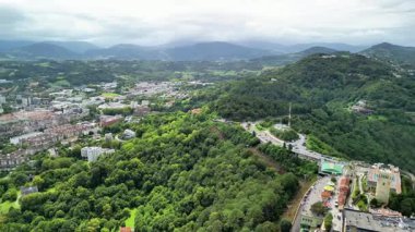 Sersemletici hava görüntüsü yemyeşil ve arka planda dağlar olan kentsel manzaralar..