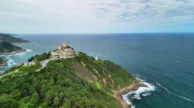 Bir hava fotoğrafı yemyeşil, güzel bir sahil şeridi ve engin okyanusun yanında tarihi bir yapı yakalar.