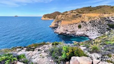 Engebeli, engebeli uçurumların berrak, pırıl pırıl mavi sularla buluşmasını gözlemleyin.