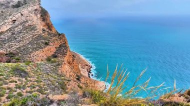 Nefes kesen uçurumlar bu huzurlu ve huzurlu kıyı manzarasında canlı turkuaz sularla çarpışıyor.