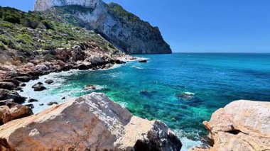Gelin ve bu nefes kesici kıyı manzarasını keşfedin çarpıcı derecede canlı mavi sular ve engebeli kayalık araziler