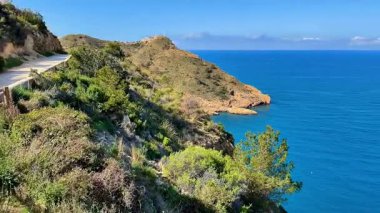 Nefes kesici okyanus manzarası yemyeşil ve açık mavi gökyüzüyle çevrili manzaralı kıyı yolu boyunca uzanır.