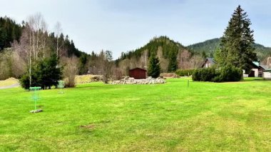 Huzurlu ve sakin yeşil bir manzara güzel yuvarlanan tepeler, kırsal ahşap kulübeler ve yemyeşil otlar sergiliyor.