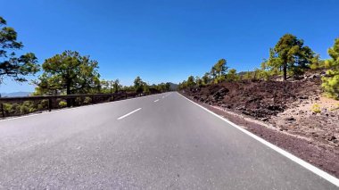 Bereketli yeşil ve çarpıcı volkanik kayalarla çevrili dolambaçlı bir dağ yolunun nefes kesici manzarasının tadını çıkarın.