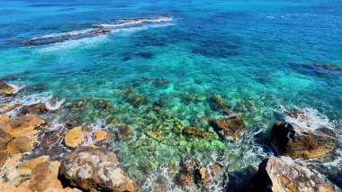 Bu nefes kesici deniz manzarası engebeli kıyı kayaları boyunca inanılmaz canlı turkuaz suları sergiliyor.