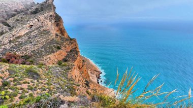 Nefes kesen uçurumlar bu huzurlu ve huzurlu kıyı manzarasında canlı turkuaz sularla çarpışıyor.