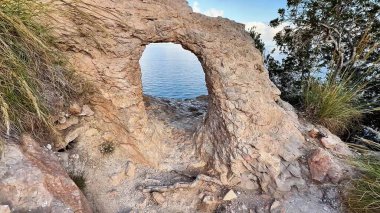 Çarpıcı bir kaya kemeri sakin suları çerçeveler, doğa severler ve fotoğrafçılar keşfetmek için mükemmel bir nokta