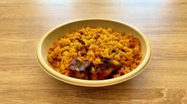 Etli ve renkli sebzeli canlı bir kase baharatlı pirinç, herkese enfes bir yemek sunar.