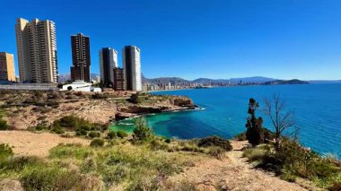 Nefes kesici bir deniz manzarası, masmavi gökyüzüne ve ışıl ışıl sulara karşı etkileyici yükselişler sergiliyor.