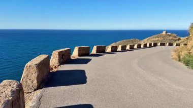 Berrak mavi sular ve büyüleyici yol kıvrımlarıyla karakterize edilmiş çarpıcı bir sahil yolculuğu yaşayın.