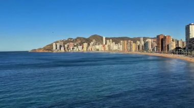 Serin bir okyanusun nefes kesen güzel manzarası berrak mavi gökyüzünün altında manzaralı bir kıyı silüeti.