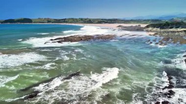 Dalgaların kayalık kıyılara çarptığı sakin bir kıyı şeridinin nefes kesici ve görkemli manzarasını deneyimleyin.