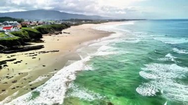 Turkuaz suları ve kumlu kıyıları dinlenmek için davet eden sakin bir plajın nefes kesici manzarasına hayran kaldım.