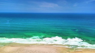 Kendini, berrak mavi sular ve nazik dalgalarla donatılmış sakin tropik bir plajın nefes kesici güzelliğine daldır.