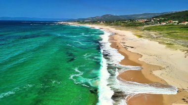 Berrak turkuaz suları, altın kumları ve yemyeşil yemyeşil sularıyla nefes kesici bir sahil manzarasının tadını çıkar.