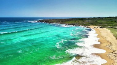 Canlı turkuaz suları, yumuşak kumlu plajları ve yemyeşil kıyı şeridini gösteren güzel bir hava manzarası.