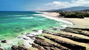 Nefes kesici plaj manzaraları sergiliyor. Sersemletici yeşil sular, yumuşak kumlu kıyılar ve resimli kıyı manzaraları.