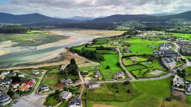 Havadan bakıldığında, bereketli tarlalar ve dağlarla çevrili bir sahil kasabasının nefes kesici bir manzara yarattığını görüyoruz.