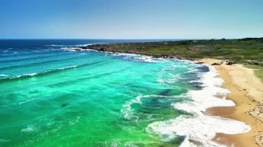 Canlı turkuaz suları, yumuşak kumlu plajları ve yemyeşil kıyı şeridini gösteren güzel bir hava manzarası.