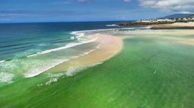 Bu manzaralı sahil manzarası güzel ve berrak gökyüzünün altında kumlu kıyıların yanında canlı turkuaz suları sunar.