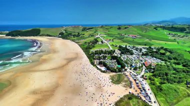 Kumlu sahillerin, gök mavisi dalgaların ve yemyeşil yeşilliklerin yer aldığı büyüleyici bir plaj manzarası keşfedin.