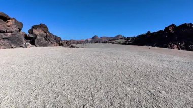 Sersemletici çöl manzarası her yerde kuru zemin, engebeli kayalar tarafından çerçevelenmiş güzel, berrak mavi gökyüzünün altında