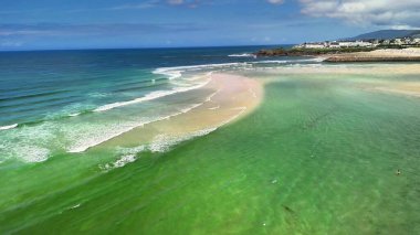 Bu manzaralı sahil manzarası güzel ve berrak gökyüzünün altında kumlu kıyıların yanında canlı turkuaz suları sunar.