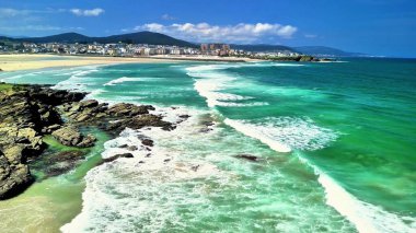 Nefes kesici manzara turkuaz suların berrak mavi gökyüzünün altında kumlu kumsalla güzel bir şekilde buluşmasını içeriyor.