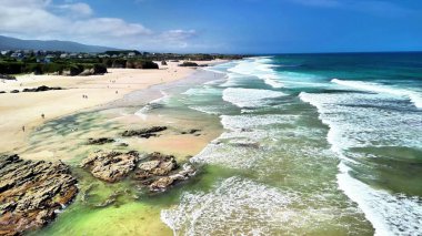 Yumuşak dalgaların ve kumlu sahillerin olduğu sakin bir sahil manzarası. Rahatlamak için mükemmel..