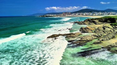 Canlı suları, kumlu plajları ve açık mavi gökyüzünün altındaki kayalık kıyıları barındıran güzel deniz manzarası..