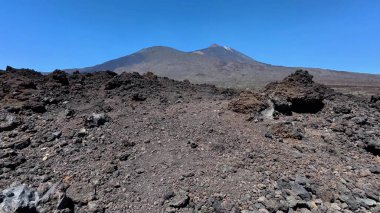 Engebeli volkanik araziyi ve büyüleyici masmavi gökyüzünün altındaki görkemli dağları keşfedin.