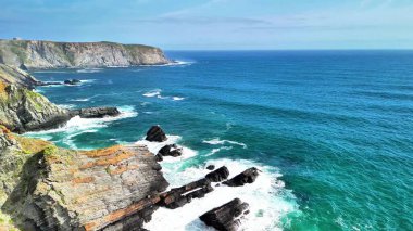 Engebeli kıyı şeridini ve dalgalı okyanus dalgalarının çarpışını gösteren nefes kesici hava görüntülerini deneyimleyin.