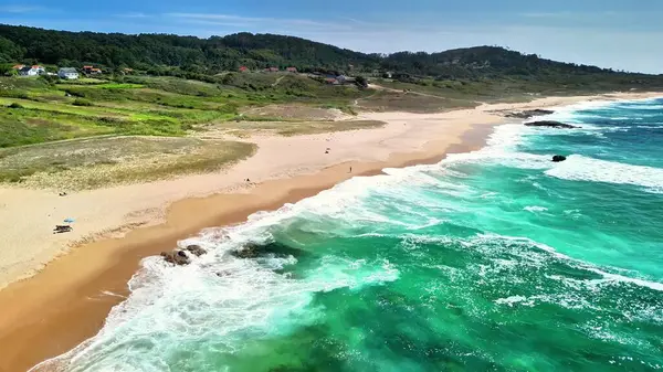 Nefes kesen hava manzarası büyüleyici derecede el değmemiş kumlu bir sahili canlı turkuaz okyanus dalgalarıyla birlikte gösteriyor.