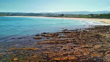 Bu sakin bir sahilin nefes kesici bir görüntüsü, engebeli kayalar ve dalgaların yanında pürüzsüz kumlu kıyılar var.