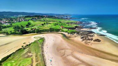 Nefes kesici bir hava fotoğrafı canlı doğal manzaralarla çevrili sakin bir sahili yakalar.