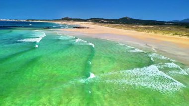 Nefes kesici hava görüntüsü, el değmemiş, el değmemiş bir plajı canlı turkuaz sularla güzel bir şekilde gösteriyor.