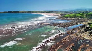 Kayalık kıyıları ve canlı mavi suları olan nefes kesici bir kıyı manzarası, dinlenmek için ideal.