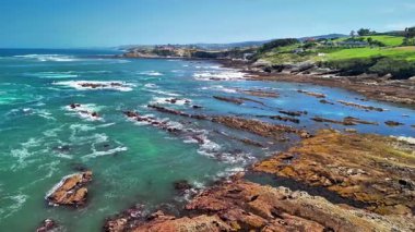 Engebeli kayaların yanında berrak turkuaz suların sergilendiği çarpıcı kıyı manzarasını deneyin.