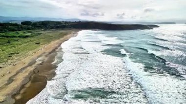 Nefes kesici bir hava manzarası muhteşem okyanus dalgalarının el değmemiş kumsalda usulca yuvarlandığını gösteriyor.,