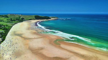 Temiz turkuaz suları ve kumlu kıyıları olan güzel bir sahili gösteren nefes kesici bir hava görüntüsü..