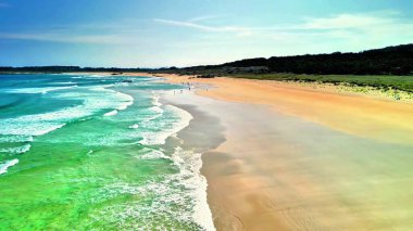Nefes kesici bir hava manzarası, pırıl pırıl turkuaz dalgaları ve yumuşak, altın kumu olan el değmemiş bir plajı sergiliyor.