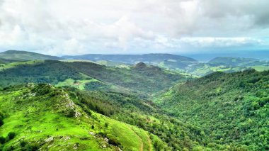 Nefes kesen panoramik manzara yemyeşil tepeler ve güzel bulutlu gökyüzünün altında geniş vadiler sergiliyor.