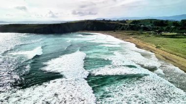 Çarpıcı hava görüntüleri, güçlü okyanus dalgalarını fevkalade bir şekilde yakalıyor ve güzel bir sahil şeridine çarpıyor.