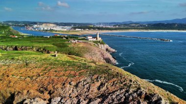 Çarpıcı bir kıyı manzarası resim gibi bir deniz feneri, engebeli uçurumlar ve canlı bir marinaya sahiptir.