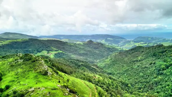 Nefes kesen panoramik manzara yemyeşil tepeler ve güzel bulutlu gökyüzünün altında geniş vadiler sergiliyor.