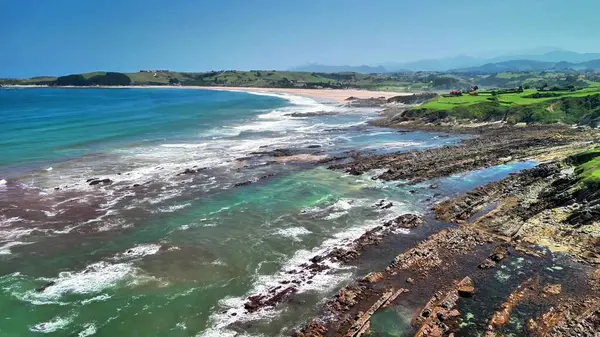 Kayalık kıyıları ve canlı mavi suları olan nefes kesici bir kıyı manzarası, dinlenmek için ideal.