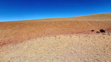 Uçsuz bucaksız, kurak bir arazinin nefes kesici manzarası. Toprak tonlarıyla dolu ve son derece el değmemiş mavi gökyüzü.